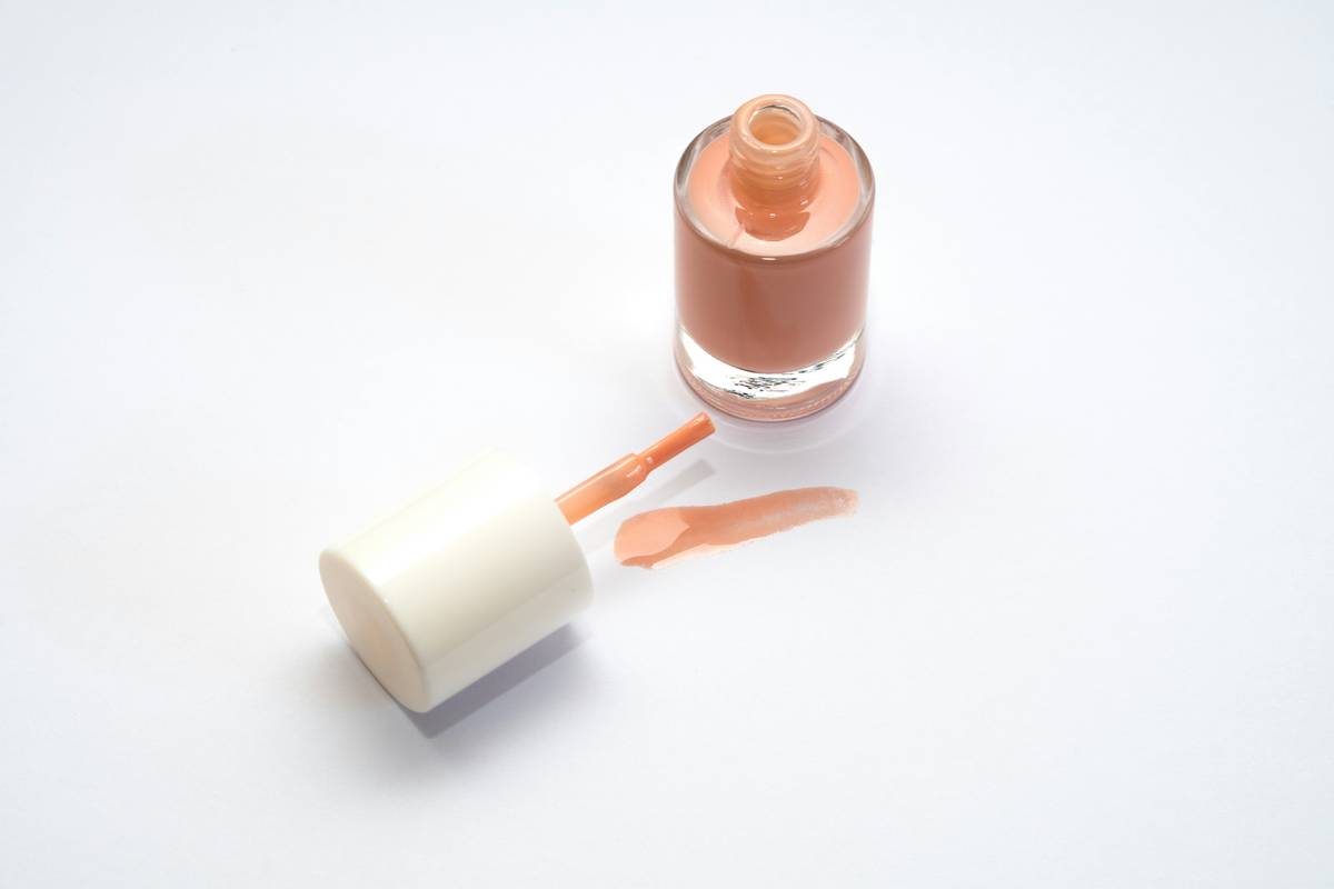 Infographic showing how nail oils block polish adhesion vs. clean, prepped nail surface allowing strong bond